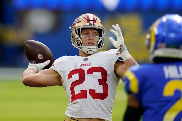 San Francisco 49ers running back Christian McCaffrey, left, passes for a touchdown on a trick play as Los Angeles Rams cornerback Troy Hill watches during the first half of an NFL football game Sunday, Oct. 30, 2022, in Inglewood, Calif. (AP Photo/Gregory Bull)