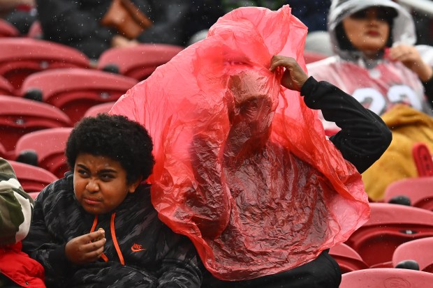 Football fans begin to shield themselves from the rain before the start of the NFC wild-card playoff game at Levi's Stadium in Santa Clara, Calif., on Saturday, Jan. 14, 2023. (Jose Carlos Fajardo/Bay Area News Group)