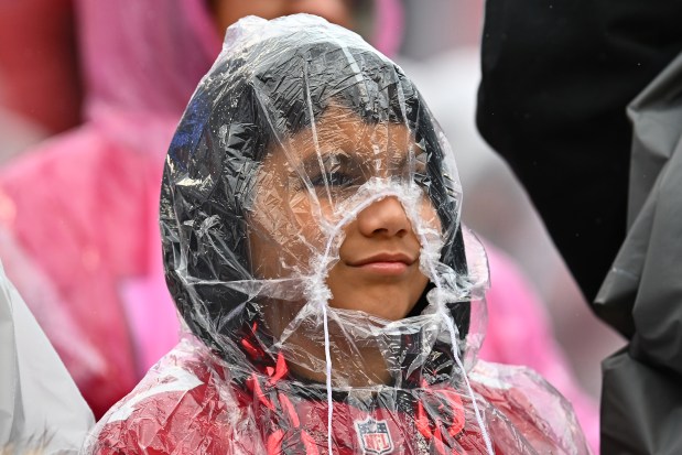 A young football fan shields himself from the rain before the start of the NFC wild-card playoff game at Levi's Stadium in Santa Clara, Calif., on Saturday, Jan. 14, 2023. (Jose Carlos Fajardo/Bay Area News Group)