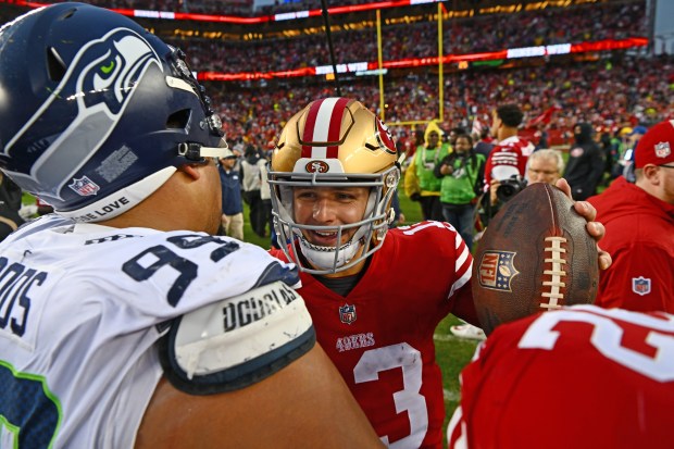 San Francisco 49ers quarterback Brock Purdy (13) is all smiles as he is congratulates by Seattle Seahawks' Al Woods (99) after their NFC wild-card playoff game at Levi's Stadium in Santa Clara, Calif., on Saturday, Jan. 14, 2023. The San Francisco 49ers defeated the Seattle Seahawks 41-23. (Jose Carlos Fajardo/Bay Area News Group)