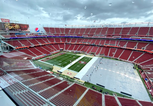The Levi's Stadium grounds crew removes the tarp during a break in the rain three hours before the San Francisco 49ers host the Seattle Seahawks in a NFL playoff wild-card round game on January 14, 2023. (Cam Inman/Bay Area News Group)