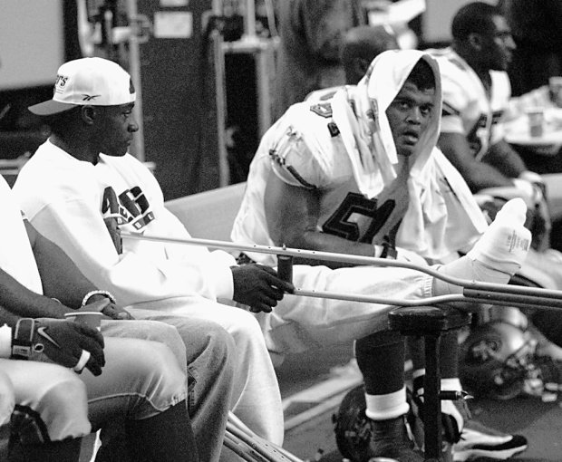 San Francisco 49ers running back Garrison Hearst sits on the bench in the fourth quarter with a broken leg during their divisional playoff game against the Atlanta Falcons on Saturday, Jan. 9, 1999 at the Georgia Dome in Atlanta. At right is Ken Norton Jr. (51). Hearst broke his leg on the first play of their 20-18 loss to the Falcons. The Falcons advance to their first NFC championship game next weekend to meet either Minnesota or Arizona. (AP Photo/Dave Martin)