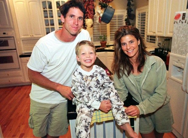 Photo of then Denver Broncos wide receiver Ed McCaffrey, left, joking around with his 5-year-old son, Christian, and wife Lisa in the family's kitchen in the southeast Denver suburb of Parker, Colo., in this photograph taken on Aug. 16, 2000. (AP Photo/David Zalubowski)