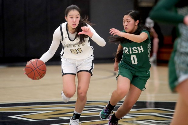 Archbishop Mitty's April Chan (21) drives past Sacred Heart Cathedral's Aniyah Versosa (0) during a West Catholic Athletic League basketball game at Archbishop Mitty High in San Jose, Calif., on Wednesday, Jan. 11, 2023. (Ray Chavez/Bay Area News Group)