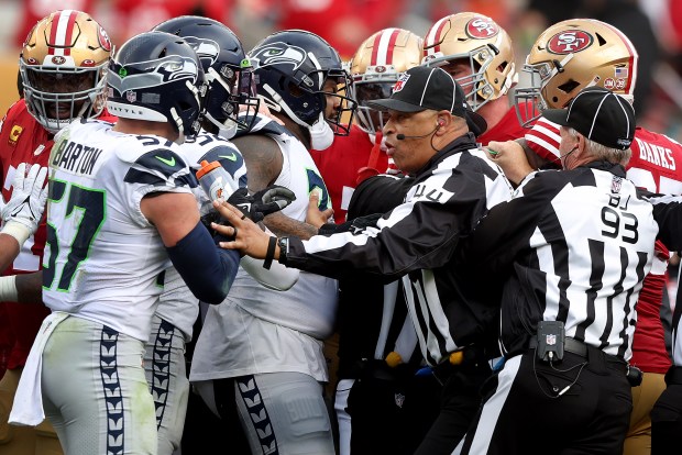 Officials try to break up an argument between the Seattle Seahawks and the San Francisco 49ers after Deebo Samuel has his ankle yanked by Seattle Seahawk's Jonathan Abram in the second half of their NFC wild-card playoff game, Saturday, Jan. 14, 2023, at Levi's Stadium in Santa Clara, Calif. (Karl Mondon/Bay Area News Group)