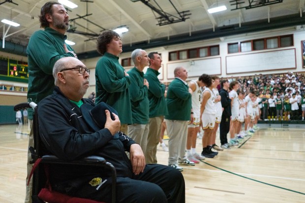 Former San Ramon Valley Boys Basketball Assistant Coach Hans de Lannoy, left, pauses for the national anthem before the start of the game at San Ramon Valley High School in San Ramon, CA on Tuesday, January 10, 2023. De Lannoy was honored before the game, and has this season dedicated to his recovery from cancer. (Don Feria for Bay Area News Group)