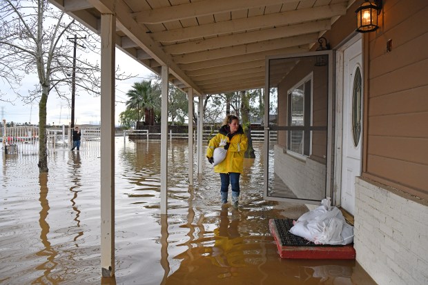 Stephanie Beard, of Brentwood, carries a sand bag to her flooded home on Bixler Road in Brentwood, Calif., on Monday, Jan. 15, 2023. (Jose Carlos Fajardo/Bay Area News Group)