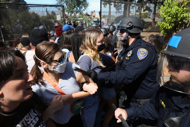 BERKELEY, CA - AUGUST 3: Police officers work to move protesters from a gate at Peoples Park on Wednesday, Aug. 3, 2022, in Berkeley, Calif. UC Berkeley plans to begin constructing housing at the site for 1,100 university students and 125 homeless residents. (Aric Crabb/Bay Area News Group)