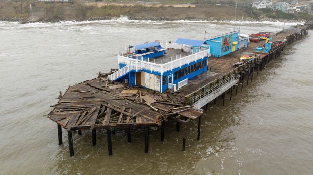 This aerial view shows a damaged pier is split in Capitola, California, on January 9, 2023. - A massive storm called a "bomb cyclone" by meteorologists has arrived and is expected to cause widespread flooding throughout the state. (Photo by JOSH EDELSON / AFP) (Photo by JOSH EDELSON/AFP via Getty Images)