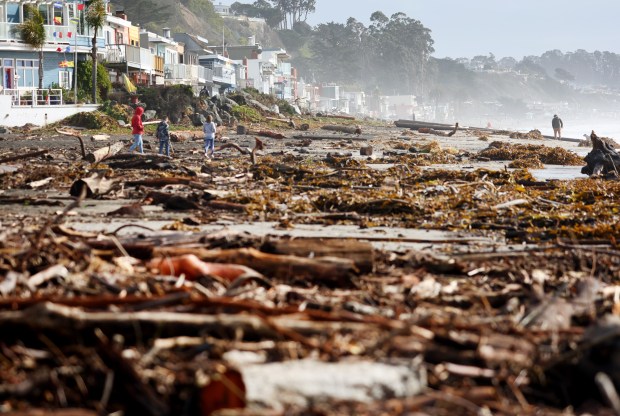 APTOS, CALIFORNIA - JANUARY 10: People walk amid storm debris washed up on the beach on January 10, 2022 in Aptos, California. The San Francisco Bay Area and much of Northern California continues to get drenched by powerful atmospheric river events that have brought high winds and flooding rains. The storms have toppled trees, flooded roads and cut power to tens of thousands. Storms are lined up over the Pacific Ocean and are expected to bring more rain and wind through the end of the week. (Photo by Mario Tama/Getty Images)