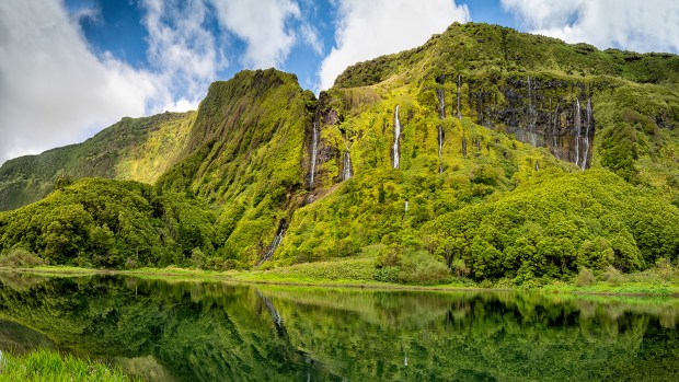 Waterfalls trickle down an imposing rock face on the island Flores in the Azores.(aroxopt/Adobe Stock via CNN)