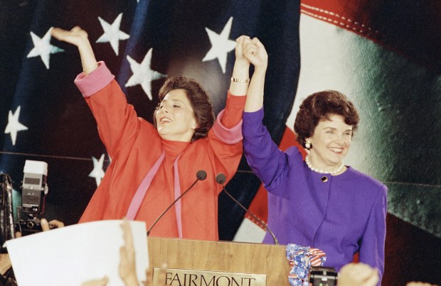 Democratic Senate candidates Barbara Boxer, left, and Dianne Feinstein raise their arms in victory and wave to supporters at an election rally in San Francisco, Tuesday, Nov. 4, 1992. The two women claimed victory over their Republican male rivals, Bruce Herschensohn and Sen. John Seymour. (AP Photo/Alan Greth)