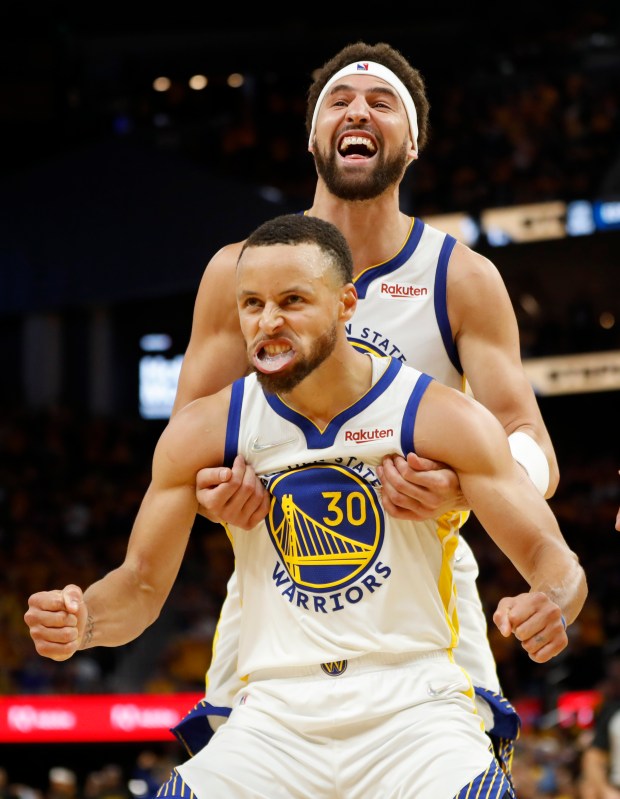 Golden State Warriors' Klay Thompson and Stephen Curry (30) celebrate the final moments of their fourth quarter comeback victory over the Dallas Mavericks in Game 2 of their NBA Western Conference Finals playoffs at Chase Center in San Francisco on May 20. (Karl Mondon/Staff Photographer)