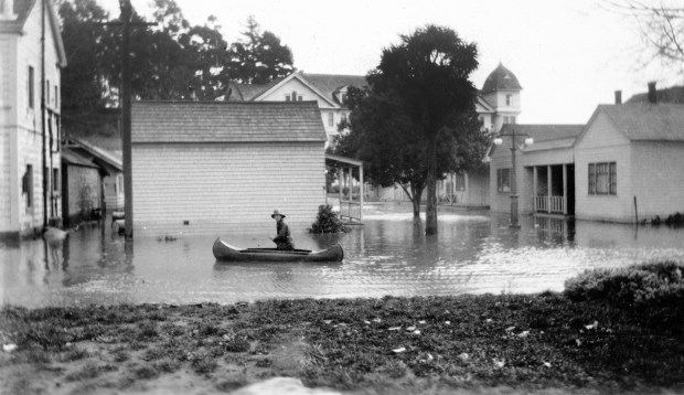 A man paddles a canoe through a flooded Capitola Village a half-block from the beach after a 1926 storm. (courtesy of Capitola Historical Museum -- Macdonald Collection)