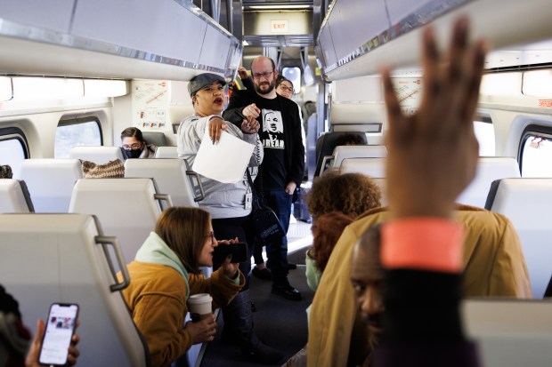 Caltran's Communications Manager Tasha Bartholomew, center, quizes passengers on Dr. Martin Luther King Jr. while the group rides the Caltrain NorcalMLK Celebration Train on Dr. Martin Luther King Jr. Day on Jan. 16, 2023. (Dai Sugano/Bay Area News Group)