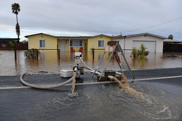 Ray Orosco, of Brentwood, uses pumps in an attempt to pump water surrounding his flooded home on Bixler Road in Brentwood, Calif., on Monday, January 16, 2023. (Jose Carlos Fajardo/Bay Area News Group)