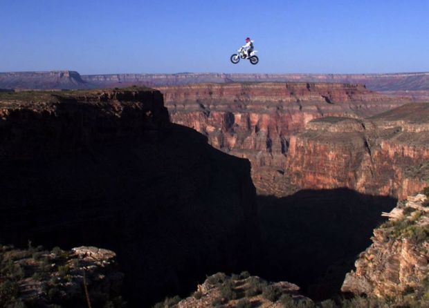 Robbie Knievel of the US is airborne above the Grand Canyon, AZ, 20 May, 1999 during a successful 228 feet (some 68 meters) world record jump. Knievel crashed following his landing and sustained unknown injuries but talked to the crowd before being flown by helicopter to the University Medical Center in Las Vegas, NV. AFP PHOTO John Gurzinski (Photo by JOHN GURZINSKI / AFP) (Photo by JOHN GURZINSKI/AFP via Getty Images)