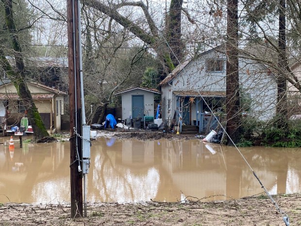 Joany Morgan's home sits in several inches of brown, muddy floodwater Sat. Jan. 14, 2023 after heavy rains from a series of atmospheric river storms swelled the nearby San Lorenzo River above flood stage for the second time in less than a week. (John Woolfolk/Bay Area News Group)
