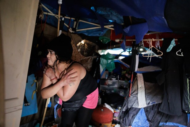 Paola Rodriguez, who has been living in a tent along Coyote Creek near Tully Road for the past four months, tries to decide what to bring when she evacuates later to a nearby library, on Wednesday, Jan. 4, 2022, in San Jose, Calif. (Dai Sugano/Bay Area News Group)