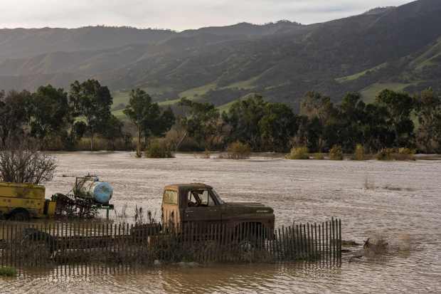 Salinas River floodwaters submerge a truck near Chualar, California, on January 12, 2023. (Photo by Nic Coury/AFP via Getty Images)