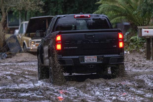 A truck drives along a muddy street in Felton, California, on January 14, 2023 as a series of atmospheric river storms continues to cause widespread destruction across the state. (Photo by David McNew/AFP via Getty Images)