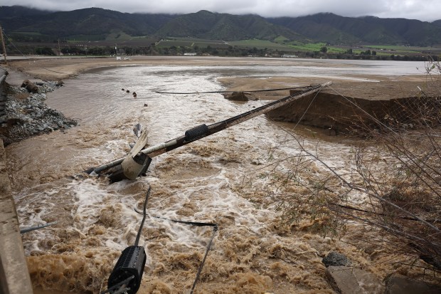 A utility pole lays in floodwaters after the Salinas River overflowed its banks on January 13, 2023 in Salinas, California. (Photo by Justin Sullivan/Getty Images)