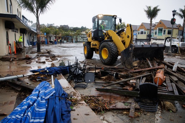 A bulldozer begins clearing debris from the street at Capitola Village after massive waves pushed seawater and debris down the street damaging bars and restaurants along Esplanade in Capitola, Calif., on Thursday, Jan. 5, 2023. (Dai Sugano/Bay Area News Group)