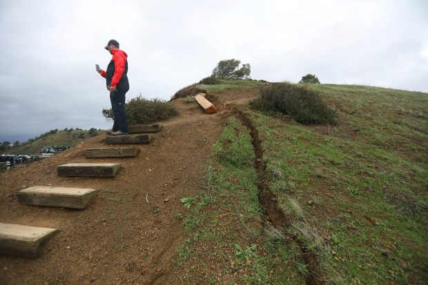 RICHMOND, CALIFORNIA - JANUARY 4: A member of the media looks over erosion damage on a hillside above Seaview Drive on Wednesday, January 4, 2023, in Richmond, Calif. Residents along the street were voluntarily evacuated due to erosion on the hill. (Aric Crabb/Bay Area News Group)
