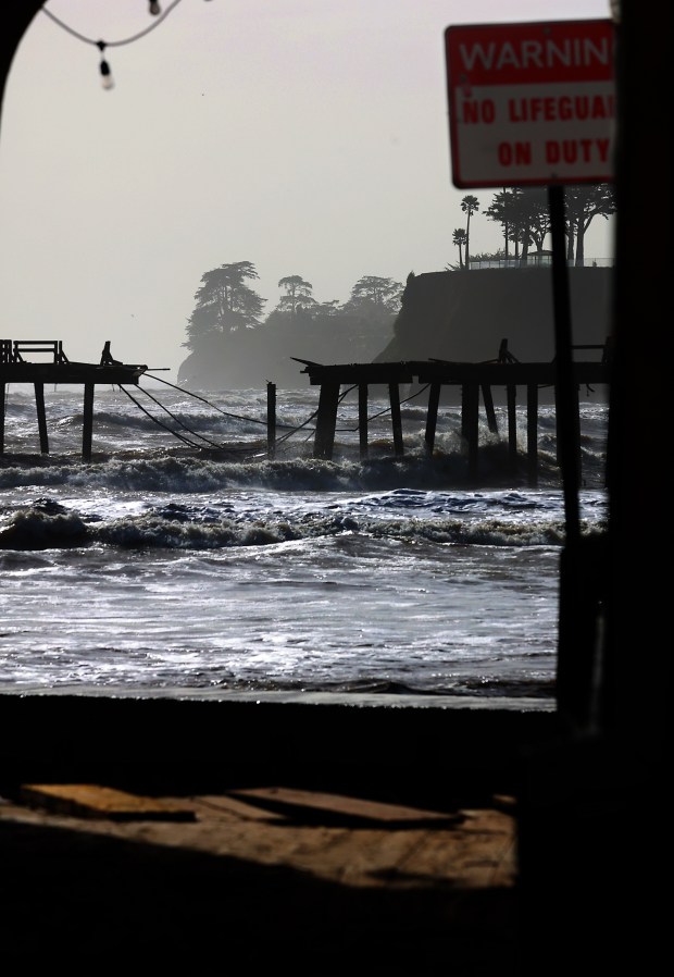 Waves in the Monterey Bay continue to batter the storm-damaged Capitola Wharf this week which is seen through a passageway on the Capitola Esplanade. Frederick Hihn built the original Capitola Wharf in the mid-19th Century with the intention of shipping lumber from the site and the structure has been destroyed and rebuilt in the same locations numerous times since then. Before our current onslaught of atmospheric rivers the wharf was severely damaged by storms in 1978, 1982 and 1985 and was eventually restored in 1998 at a cost of about a million dollars. The Capitola Wharf is actually a pier by nautical standard. Piers are berthing structures that run perpendicular to the shore while a wharf runs parallel to the shore. (Shmuel Thaler - Santa Cruz Sentinel)