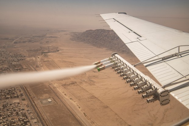 Experimental nanomaterial is released for the National Center of Meteorology and Seismology during a demonstration cloud seeding flight over in Al Ain, United Arab Emirates, March 3, 2022. As climate change makes the region hotter and drier, the UAE is leading the effort to squeeze more rain out of the clouds, and other countries are rushing to keep up. (Bryan Denton/The New York Times)